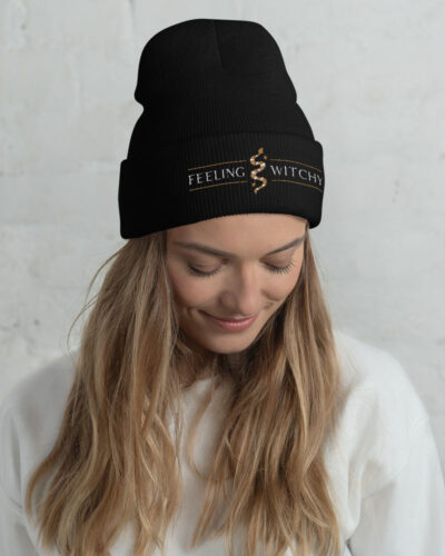 Girl with a black beanie, embroidered with "Feeling Witchy" and a snake